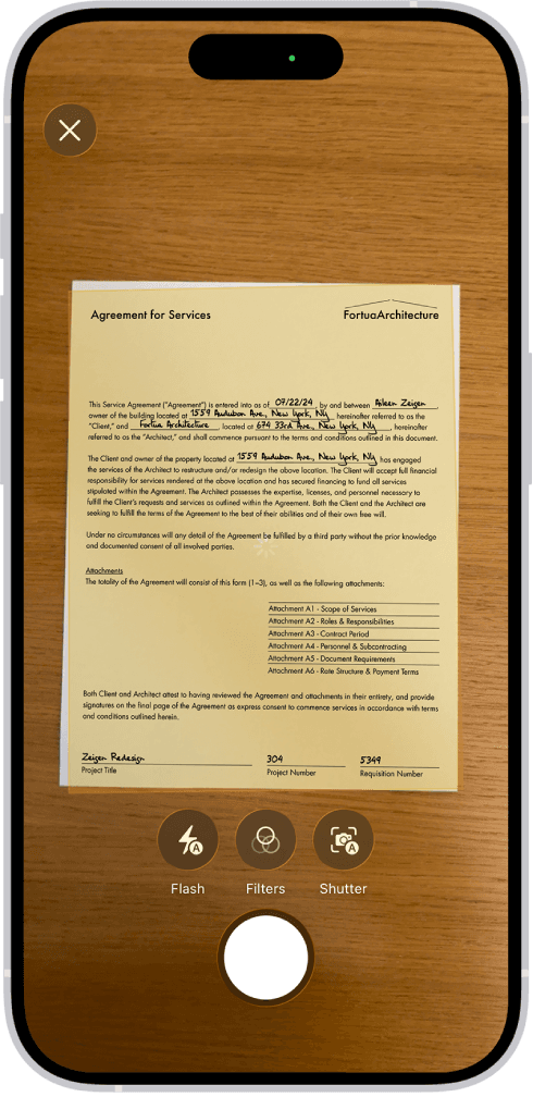The iPhone document scanner framing a signed agreement on a wooden table.